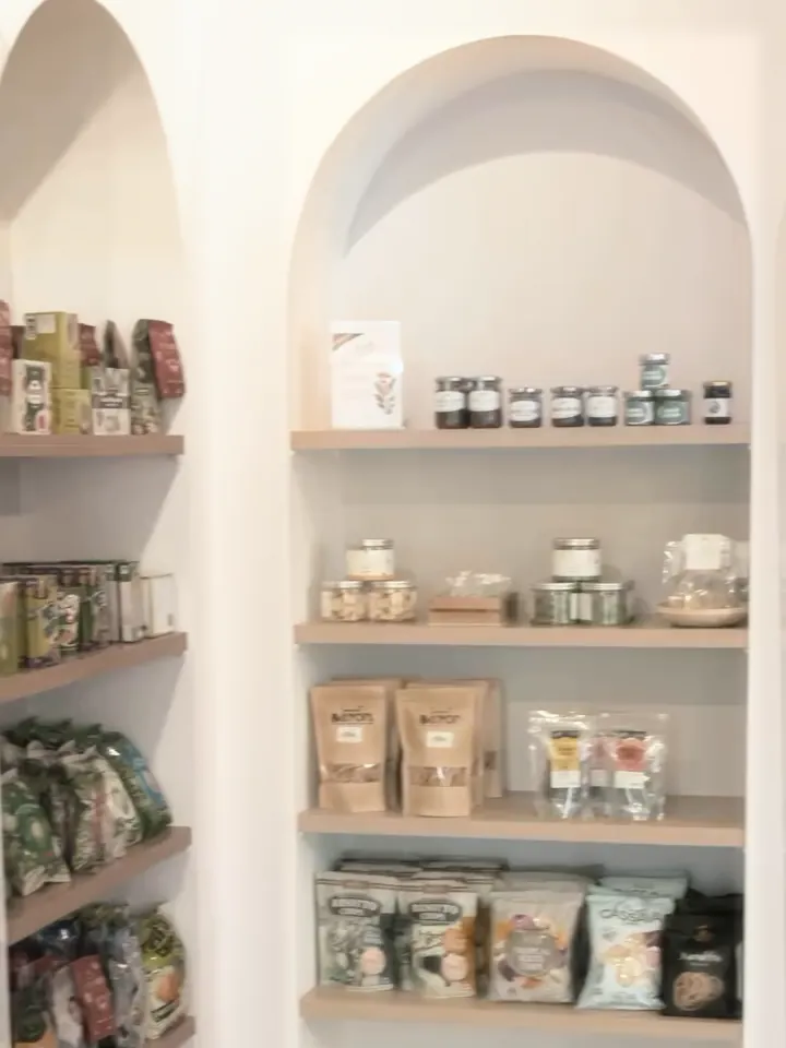 KYÔ Mart's white arched niches with light oak shelves of jars, snacks and groceries