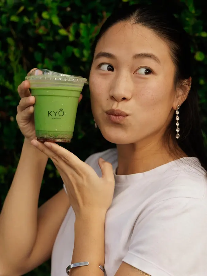 A guest with a KYÔ matcha by a window
