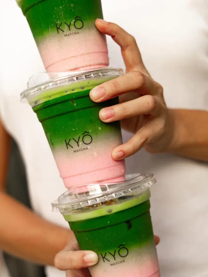 Three strawberry matcha cups stacked, pink below and green above