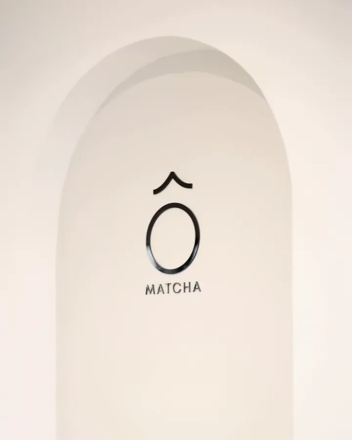 A white arched niche at KYÔ with the Ô Matcha mark in black